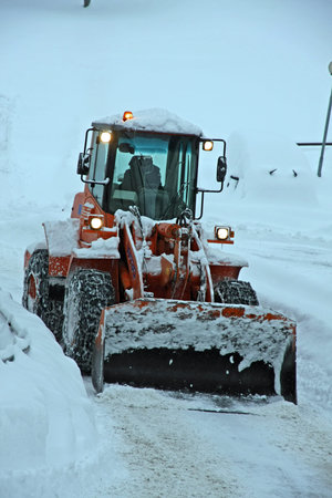 snow plough scraper with the bucket to remove all the snow from the road