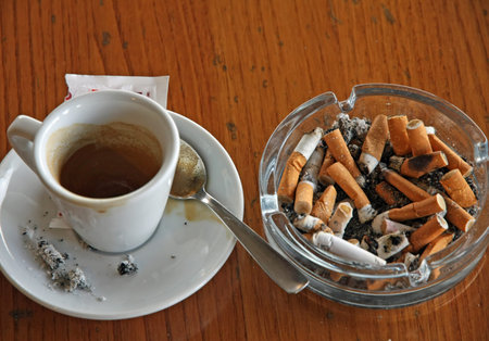 cup of coffee espresso and ashtray chock full of cigarette