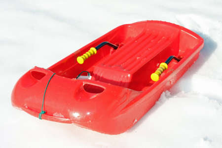 red plastic bob for play and to descend from the mountains with snowの写真素材