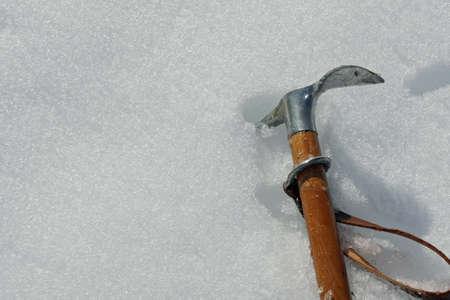 Toy axe stuck in the cold snow in the mountains in winterの写真素材