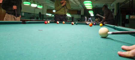 smoky poolroom with marbles on the carpet and attentive playersのeditorial素材