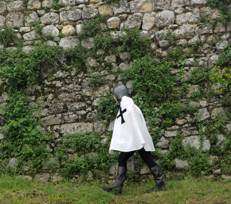 young Knight with medieval dress walking along the castle wallsの写真素材