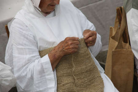 hands of an elderly woman during the processing of wool sweaterの写真素材