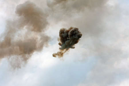 dangerous and dramatic cloud of black smoke after an explosion in the skyの写真素材