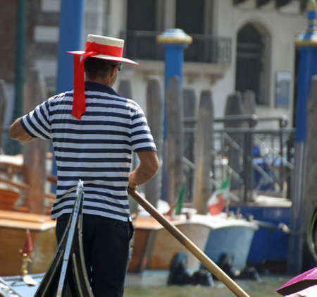 skilled Venetian gondolier as he drives his gondola on the Grand canal in Veniceの写真素材