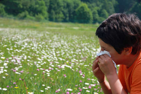 child with an allergy to pollen while you blow your nose with a white handkerchiefの写真素材