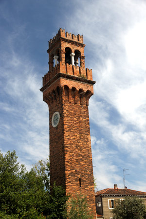 historic old high Bell Tower with clock in the island of Murano near Venice