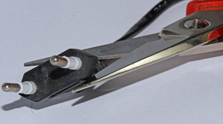 red electrician scissors that cuts an electrical outlet for sabotaging the electric plant