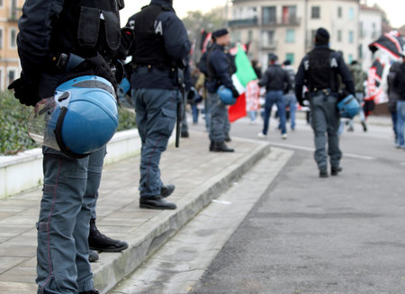 policeman in uniform and the procession of protesters in town