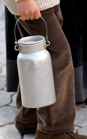 ancient old bin to transport the milk brought by a young boy