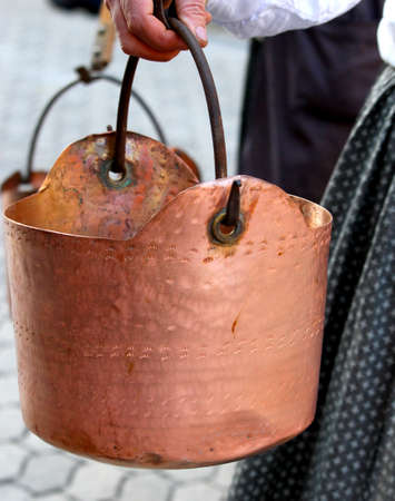 ancient copper pot carried by a peasant woman to the rural villageの写真素材