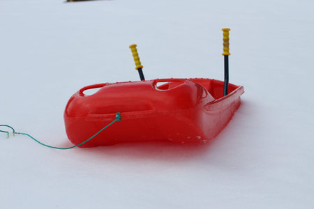 Red bob made of sturdy plastic on white snow for fun rides on the  mountain in winter