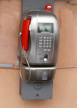 very old coin-operated italian phone with phone booth