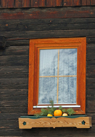 window with wooden balcony of an old House and a pumpkin on the sill