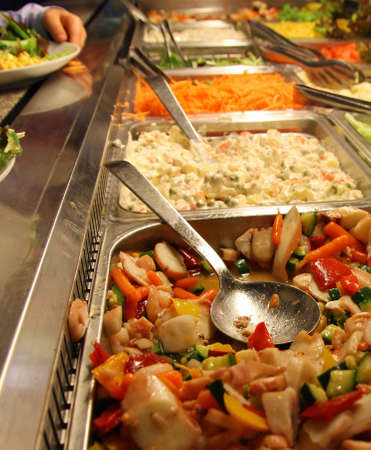 large steel trays with many delicious foods in a self-service restaurant 2の写真素材