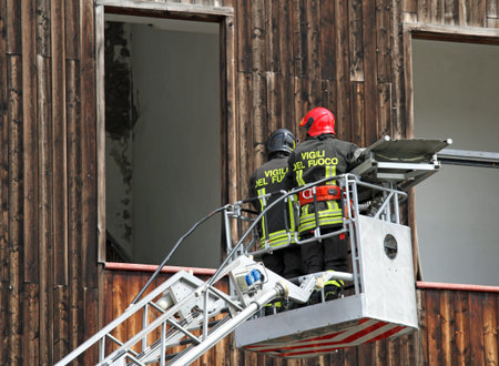 two Italian firefighters while rising with the mobile platform to free people trapped in the House during the fireの写真素材