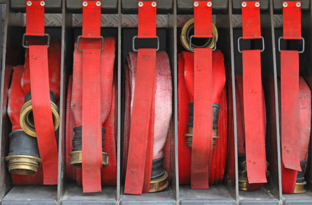 Six red hoses of firefighters in order inside the fire truck ready to put out the fire