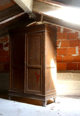 emblematic antique wardrobe in a dusty attic of a nurseryの写真素材