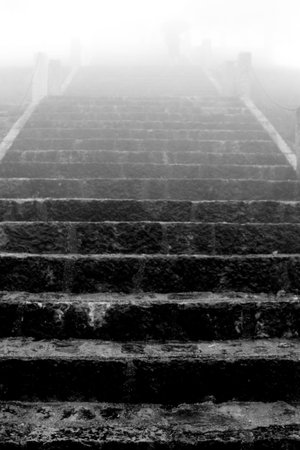 stairs uphill towards the future on a cold rainy day with a dense fog