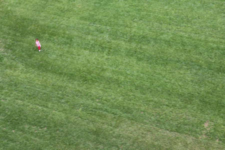 Green Lawn seen from above with a young girl who runs fastの写真素材