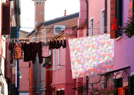 Linen stretched out in the Sun to dry between two houses on the island of Buranoの写真素材