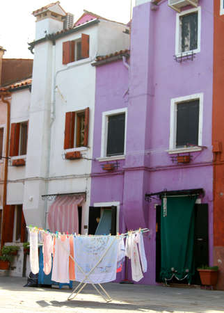 drying room with laundry stretched out to dry in the middle of the backyard of housesの写真素材