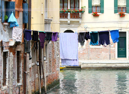 Sheets and drying laundry on the Canal full of water in Venice in Italy の写真素材