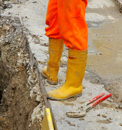 construction worker with yellow boots and a spanner in roadworks