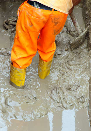 Yellow worker boots in brown mud during the flood 3の写真素材