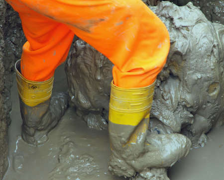 Yellow worker boots in brown mud during the flood 5の写真素材