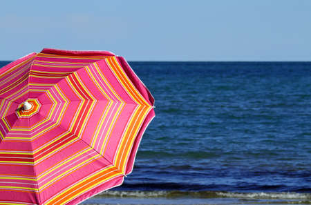 beach umbrella on the beach and the blue seaの写真素材