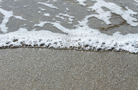 ocean waves splashing on the shore of sandy beach
