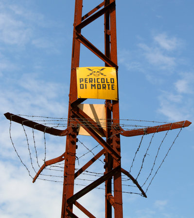 trellis  of high voltage cables with RISK of DEATH sign in Italian