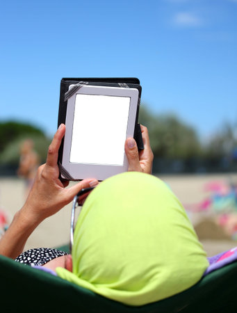 Woman read an ebook on the beach in summer