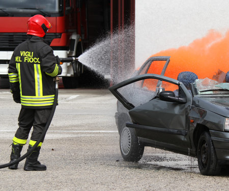 brave firefighter with helmet off the car burned with the foam
