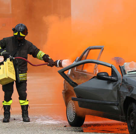 brave firefighter with helmet off the car burnedの写真素材