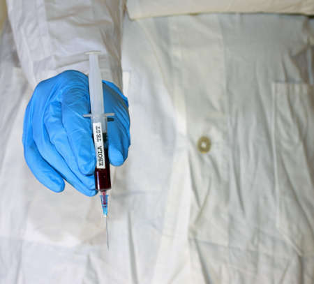 doctor with glove and the syringe of blood of ebola testの写真素材
