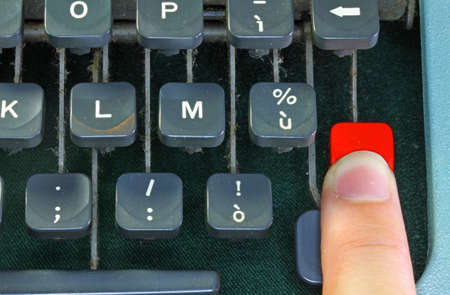 keyboard of the old typewriter with a human fingerの写真素材