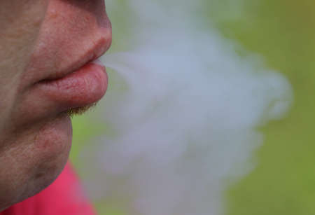 smoker throws out the smoke from his mouthの写真素材