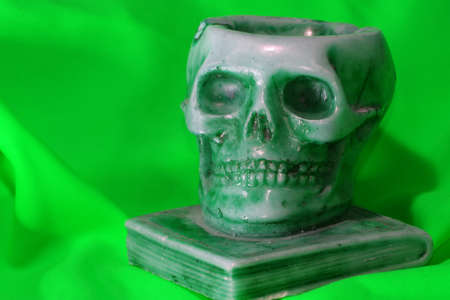 ancient human skull above a school bookの写真素材