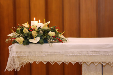 beautiful bouquet of flowers with two lit candles on the altar of the Churchの写真素材