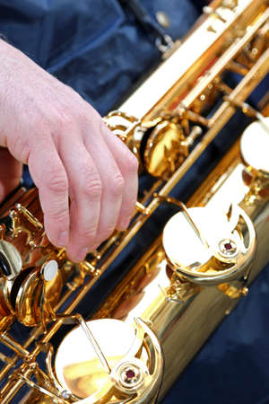 young player's hand with the Golden saxophoneの写真素材