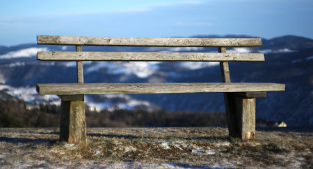 ancient wooden bench isolated in the high mountain landscape in winter