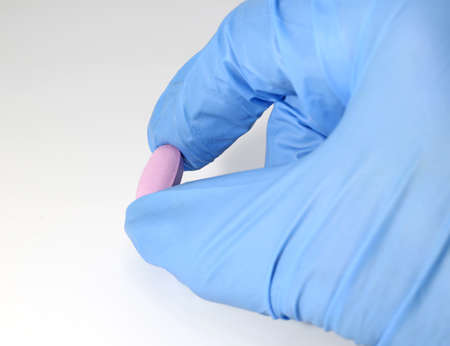 Pink pill and the doctor with the medical hygiene gloveの写真素材