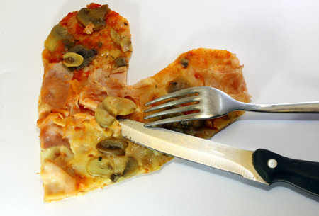 slice of pizza in the shape of a heart with a knife in the Middleの写真素材
