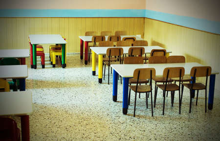 lunchroom of the refectory of the kindergarten with desks and colored chairsのeditorial素材