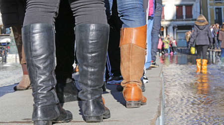 People walkingÂ onÂ theÂ catwalk in Venice Italy during at high tideの写真素材