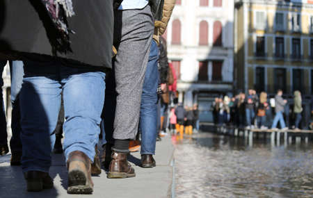 People walkingÂ onÂ theÂ catwalk in Venice Italy during at high tideの写真素材