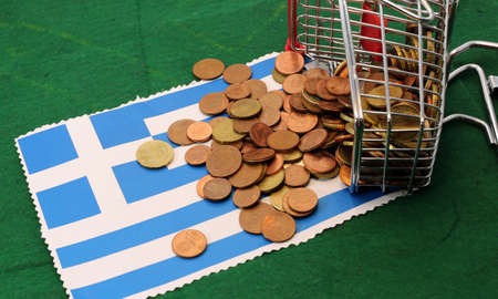 little shopping cart full of coins euro toppled over Flag of Greeceの写真素材