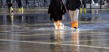 venice people with gaiters and boots at high tide in St. Mark's squareの写真素材